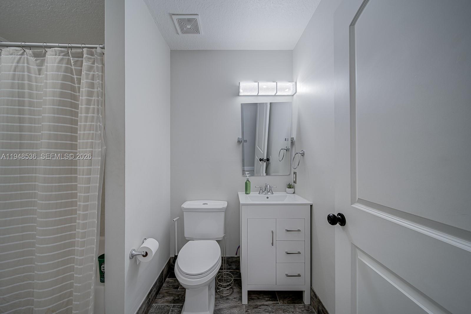 18128 Southwest 151st Avenue Miami, FL 33187 - Photo 10 of 39 a bathroom with a sink toilet and mirror