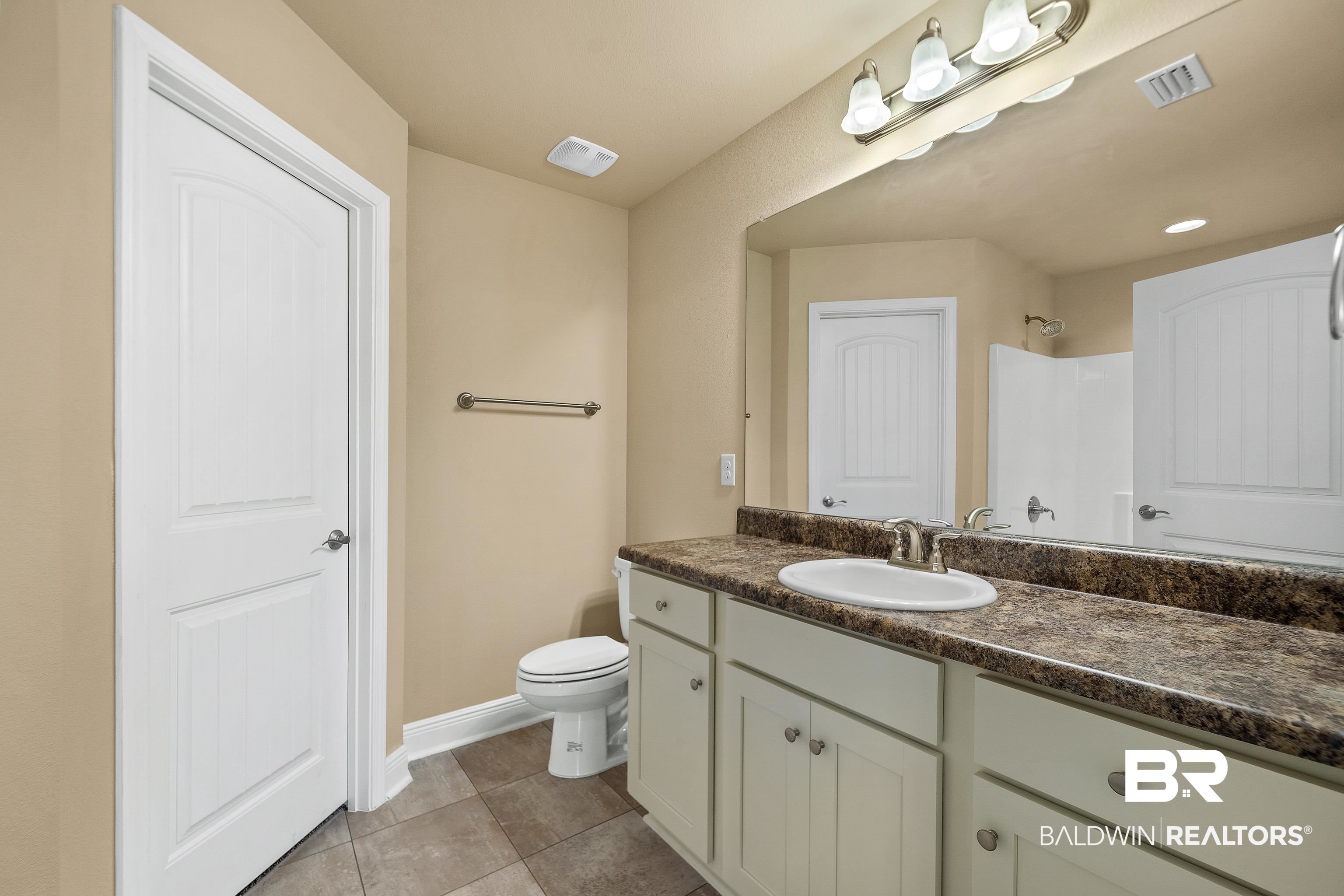 22631 Lake South Drive Foley, AL 36535 - Photo 13 of 25 Bathroom with vanity, toilet, and tile patterned floors