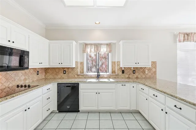 a kitchen with a sink dishwasher and white cabinets with wooden floor