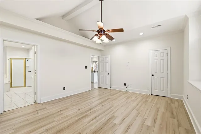 a view of a room with wooden floor and a ceiling fan