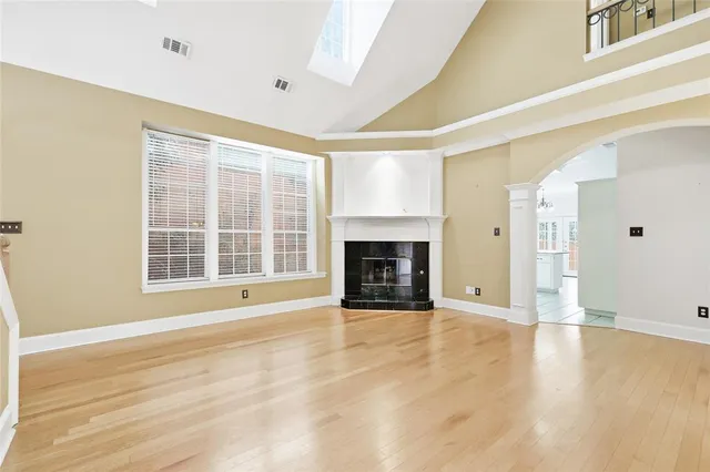 a view of an empty room with a fireplace and a window