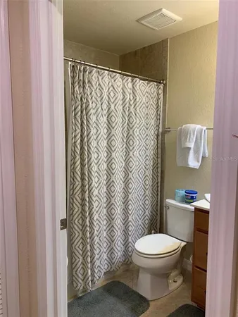 a white toilet sitting next to a shower curtain