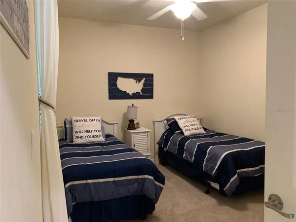 a bedroom with two beds and a chandelier