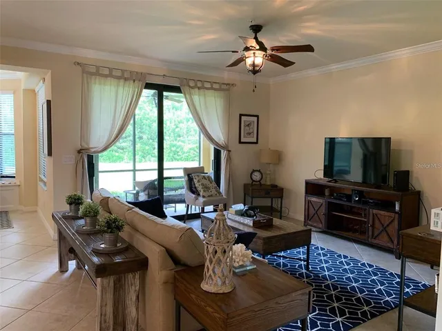 a living room with furniture a flat screen tv and a large window