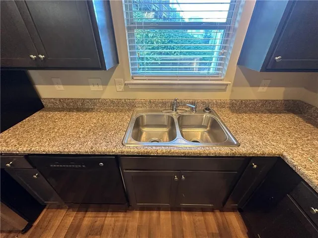 a kitchen with granite countertop sink and cabinets