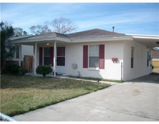 a view of a house with a yard and potted plants