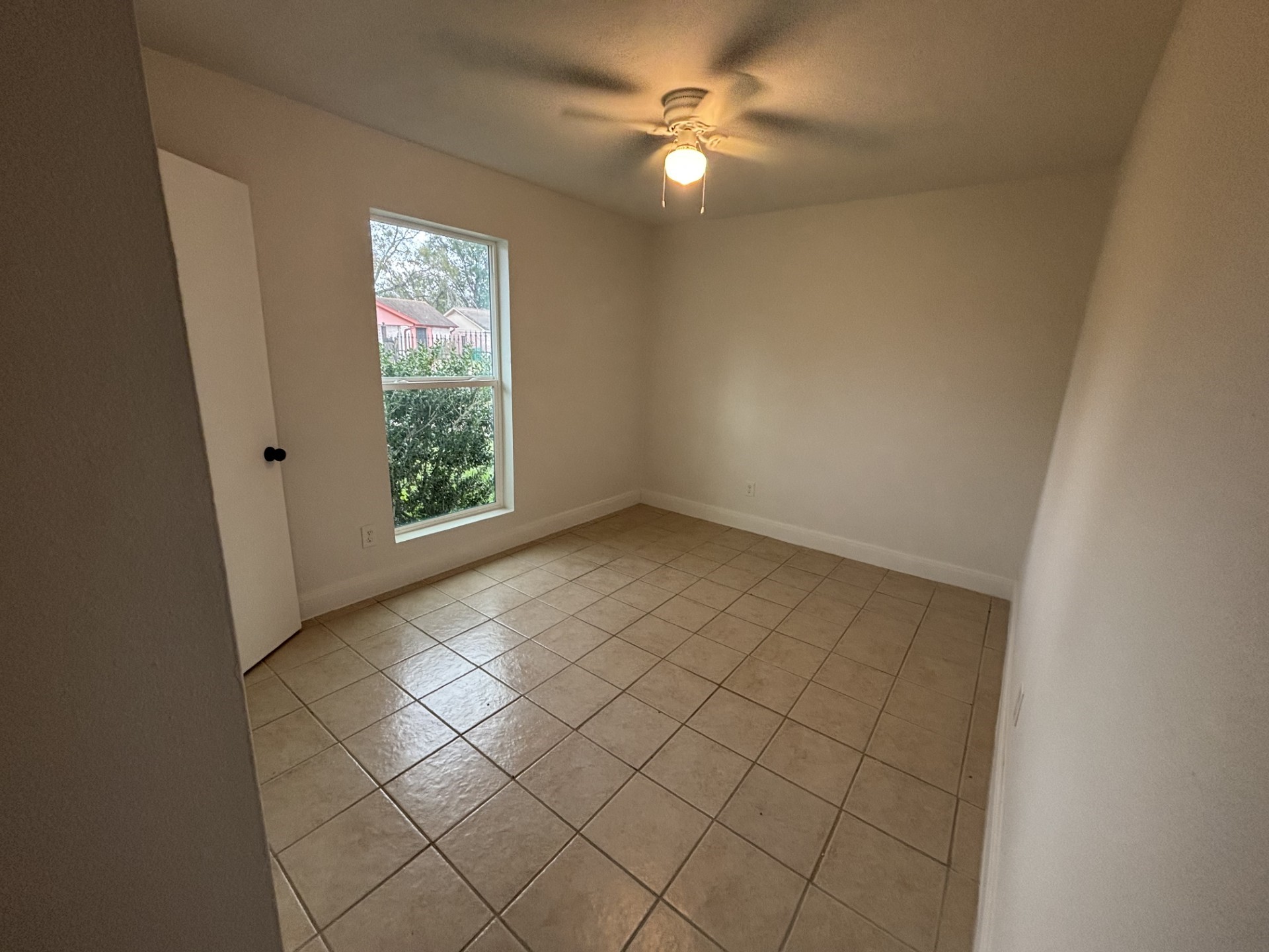 9843 Ribbonwood Street Houston, TX 77078 - Photo 13 of 14 an empty room with windows and fan