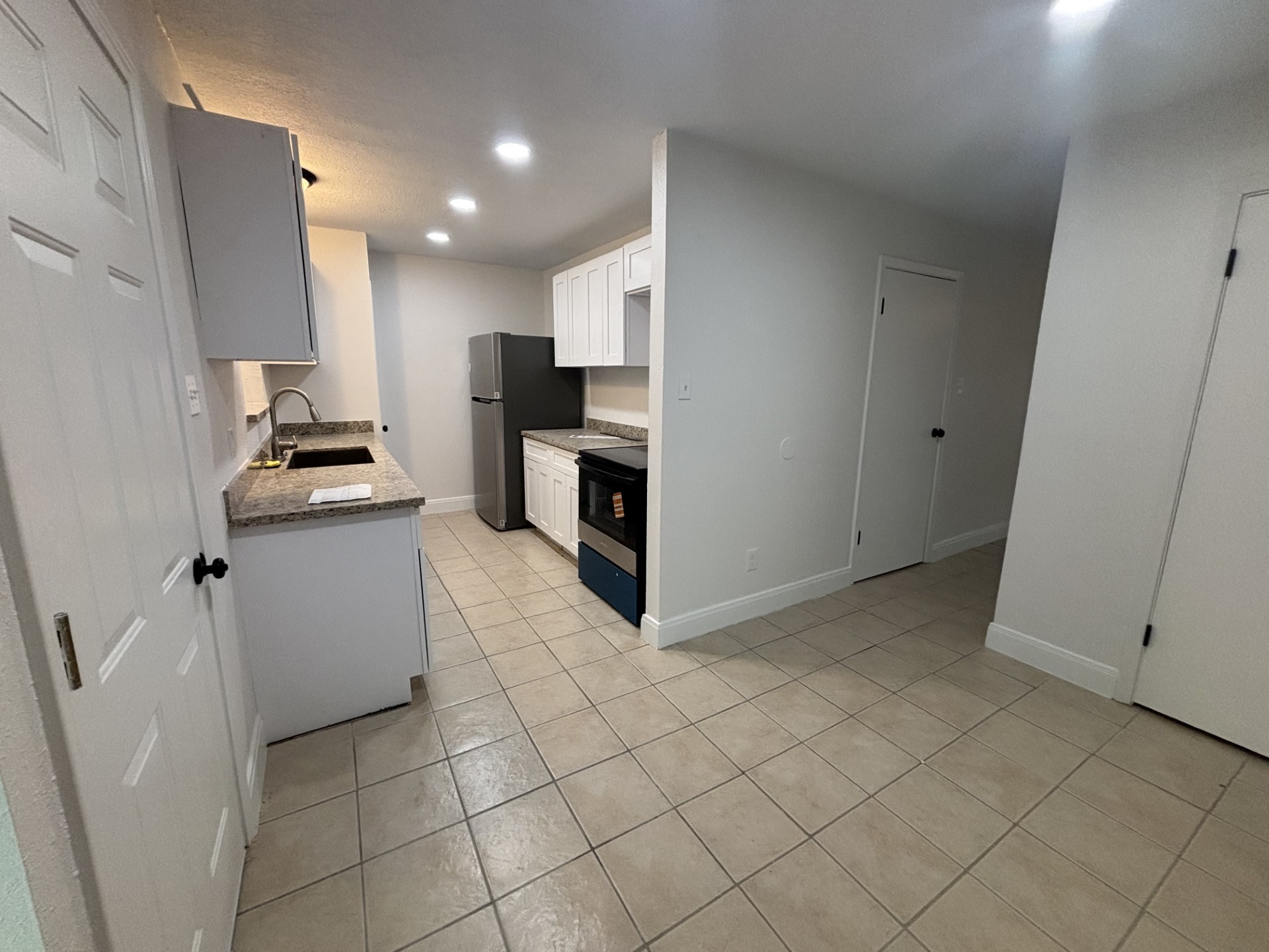9843 Ribbonwood Street Houston, TX 77078 - Photo 8 of 14 a kitchen with granite countertop white cabinets and stainless steel appliances