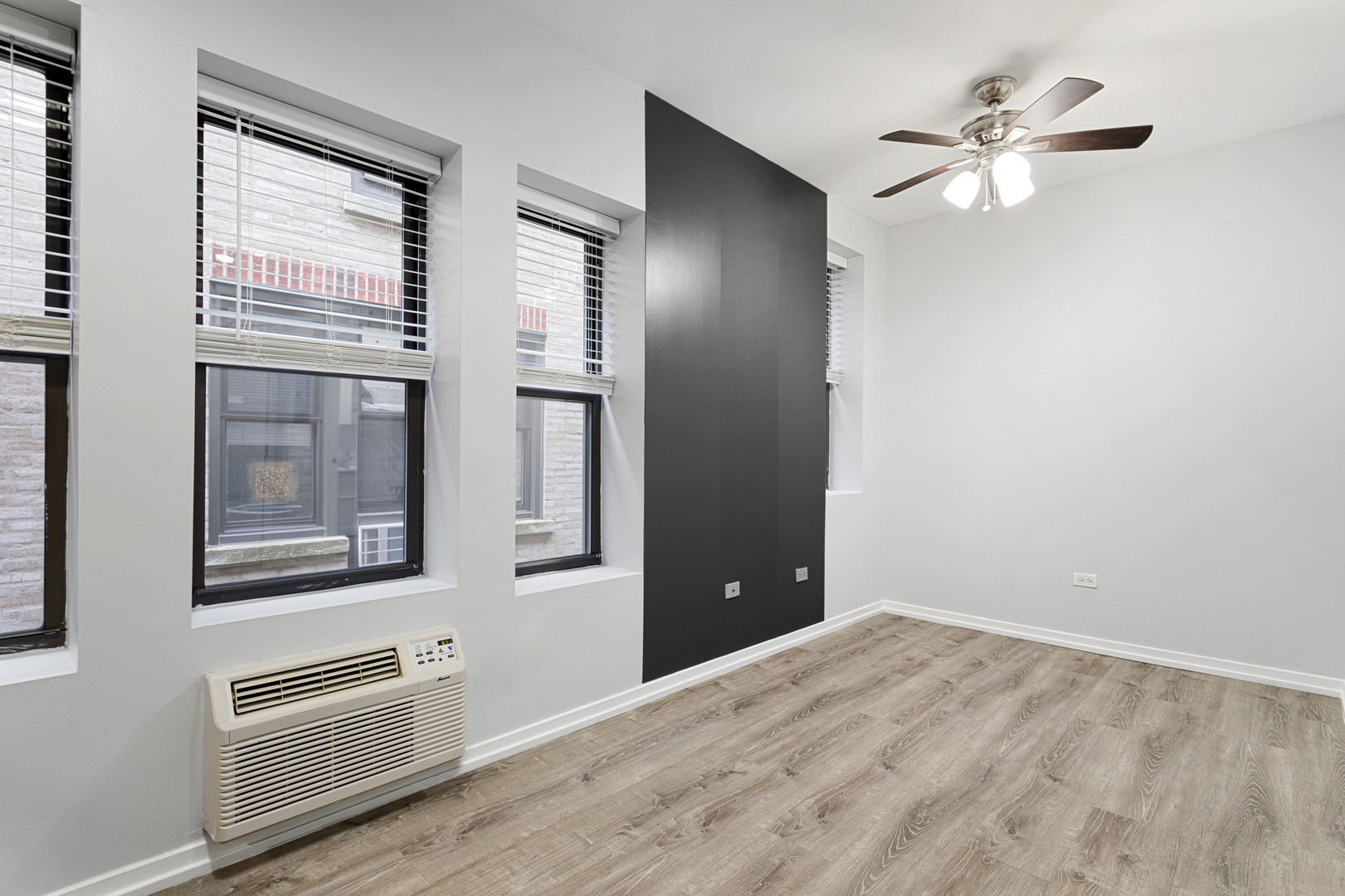 4875 North Magnolia Avenue, Unit 112 Chicago, IL 60640 - Photo 6 of 12 a view of an empty room with a ceiling fan and windows