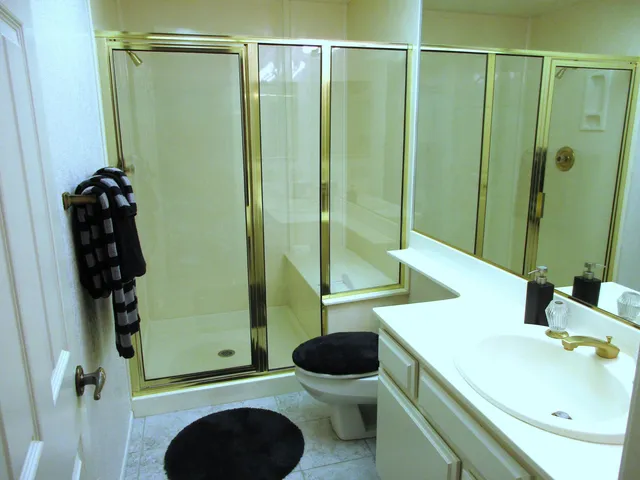 a bathroom with a sink a toilet and shower