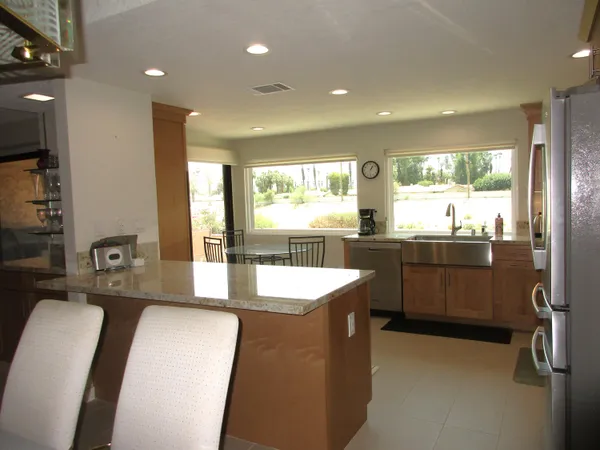 a kitchen with a sink and large windows