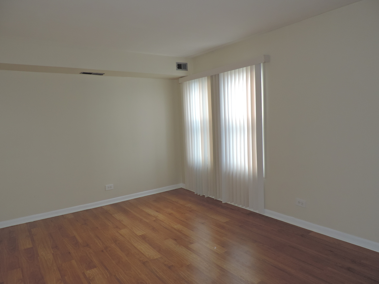2275 Country Club Drive, Unit 25 Woodridge, IL 60517 - Photo 8 of 8 a view of an empty room with wooden floor and a window