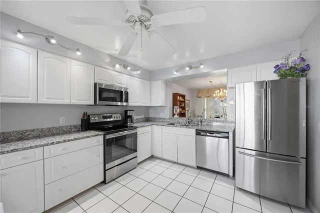 a kitchen with granite countertop stainless steel appliances and white cabinets
