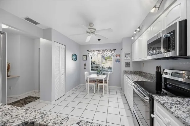 a kitchen with stainless steel appliances granite countertop a refrigerator and a stove top oven