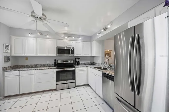 a kitchen with stainless steel appliances granite countertop a refrigerator and a stove top oven
