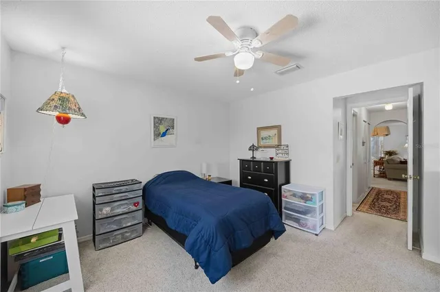 a spacious bedroom with a bed and a chandelier
