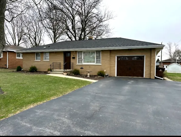a view of a house with backyard and a tree