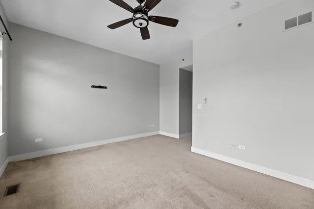 an empty room with a ceiling fan and window