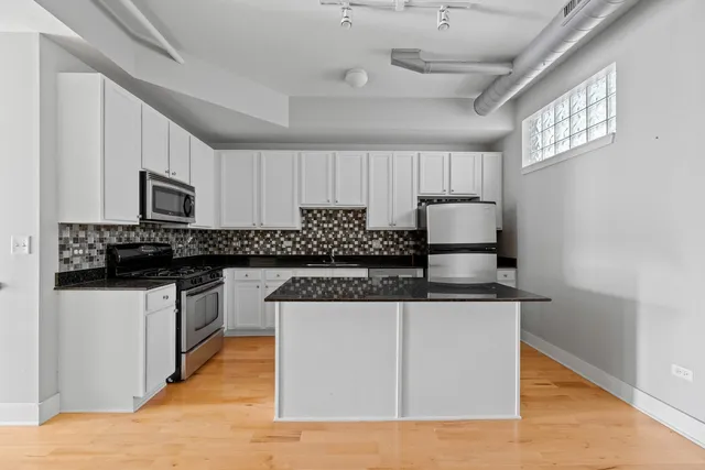 a kitchen with stainless steel appliances granite countertop a sink stove and microwave