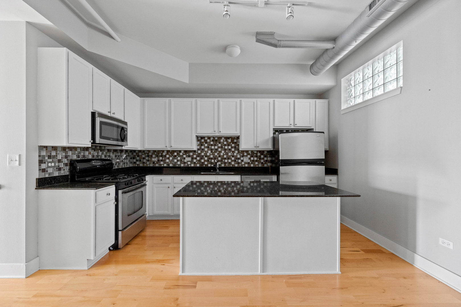 345 Front Street, Unit 2209 Lemont, IL 60439 - Photo 3 of 22 a kitchen with stainless steel appliances granite countertop a sink stove and microwave