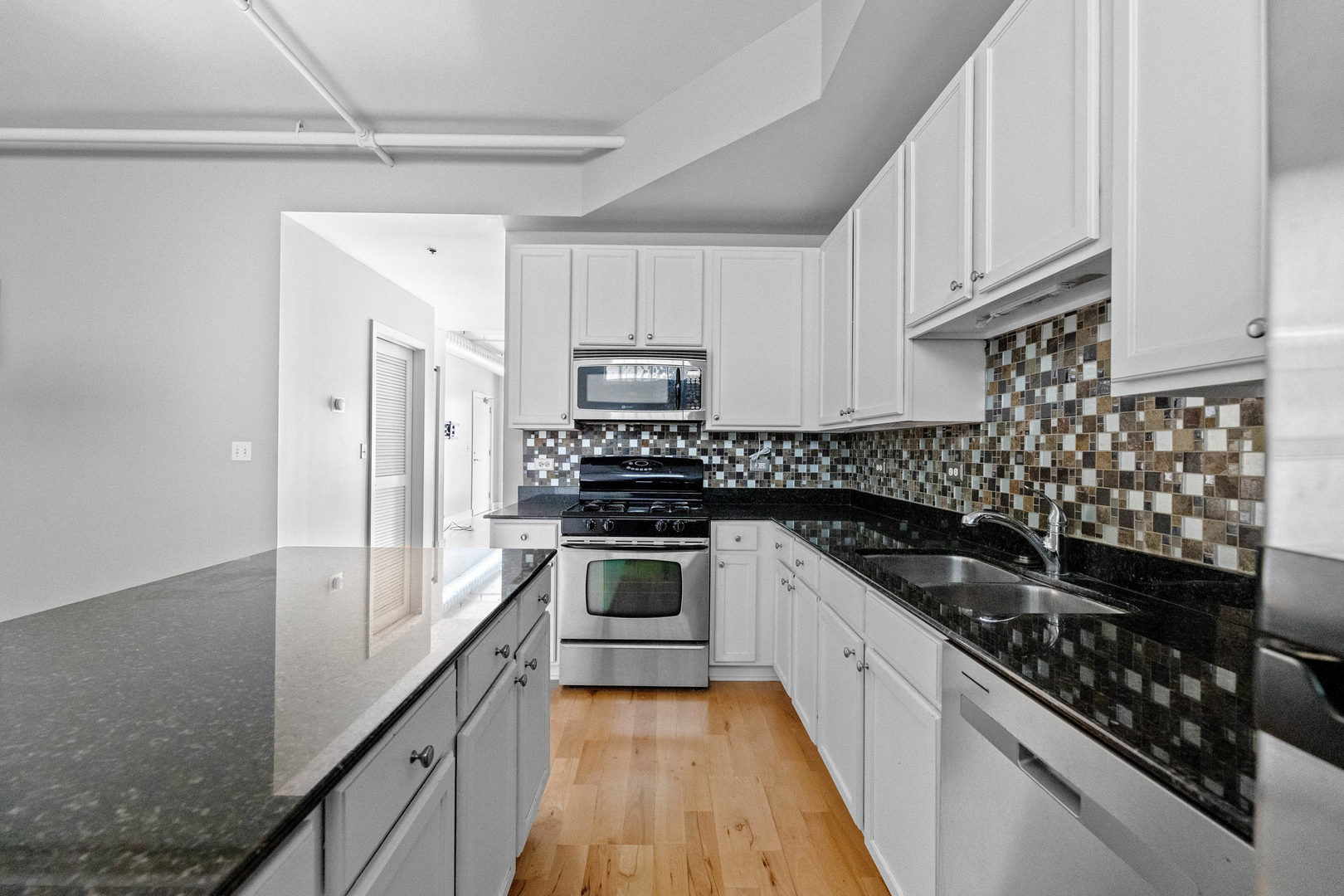 345 Front Street, Unit 2209 Lemont, IL 60439 - Photo 7 of 22 a kitchen with granite countertop a sink stove and cabinets