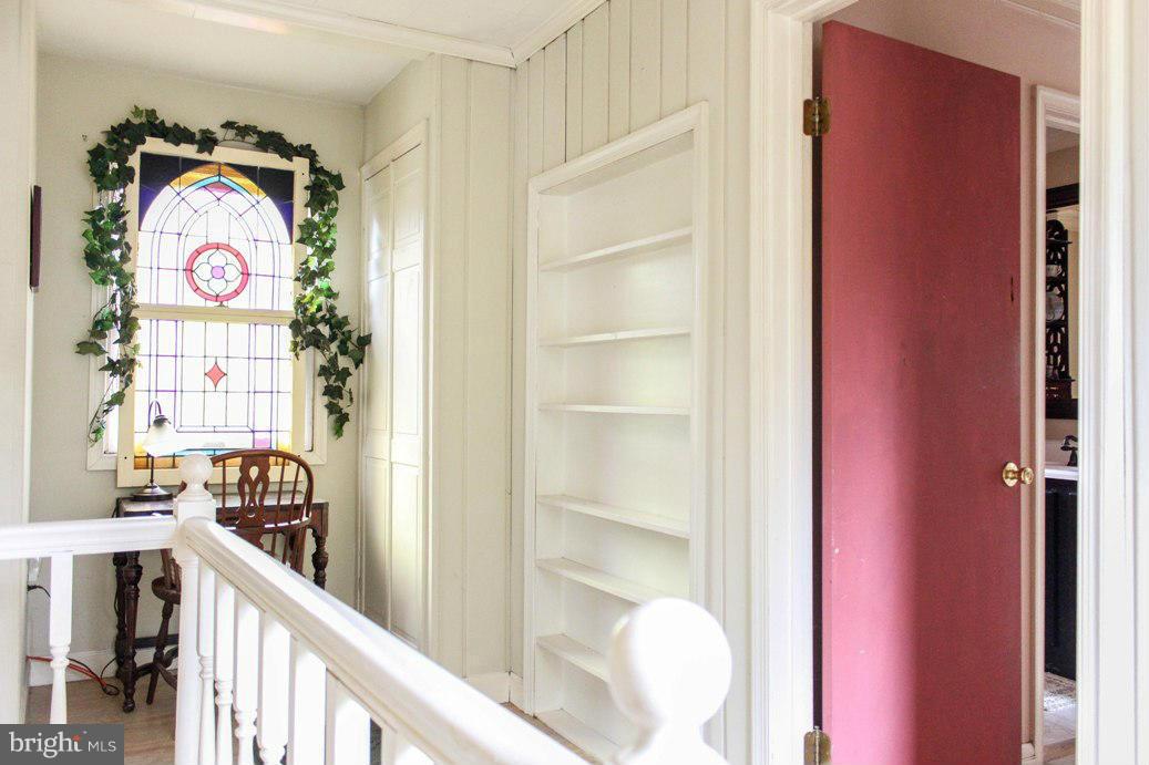 6401 Mackall Road St. Leonard, MD 20685 - Photo 25 of 30 a view of a hallway with wooden floor and a bathroom
