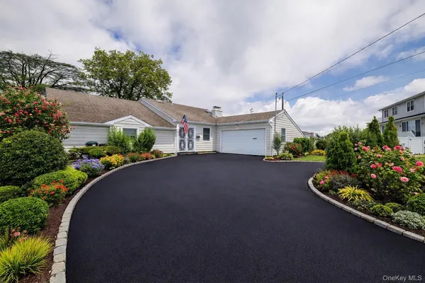 a front view of a house with a yard and a garden