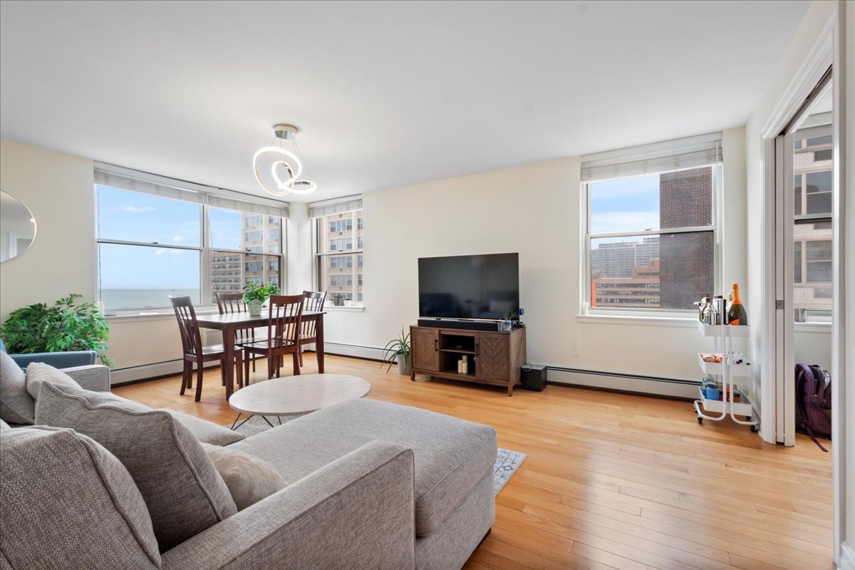 3033 North Sheridan Road, Unit 1605 Chicago, IL 60657 - Photo 3 of 21 a living room with furniture and a flat screen tv with wooden floor