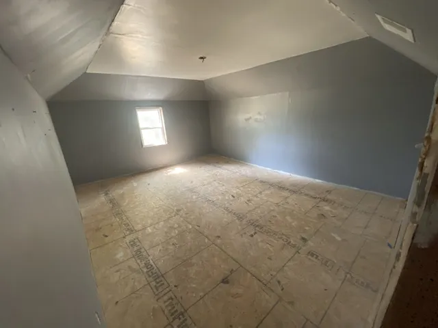 an empty room with windows and fireplace