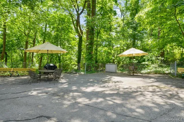 a view of a patio with a table and chairs under an umbrella