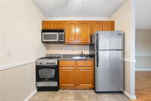 a kitchen with stainless steel appliances granite countertop a refrigerator and a stove