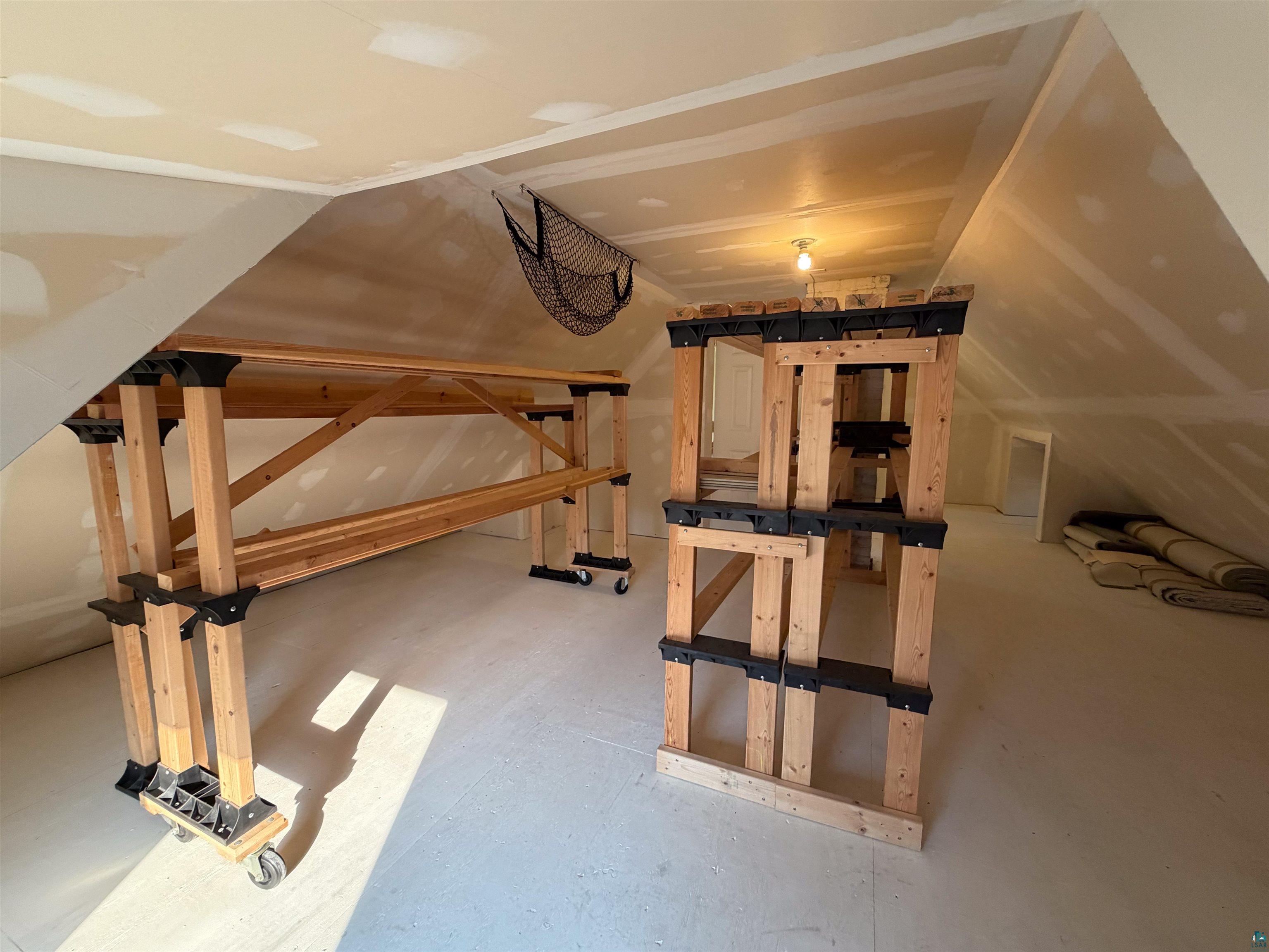 13 West 8th Street Duluth, MN 55806 - Photo 36 of 57 Attic space featuring sloped ceilings, a neutral color palette, and exposed wood framing