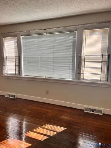 a view of a room with wooden floor and a window