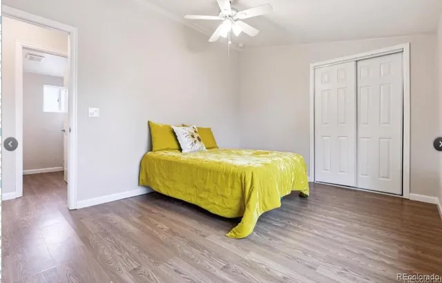 a spacious bedroom with a bed and wooden floor