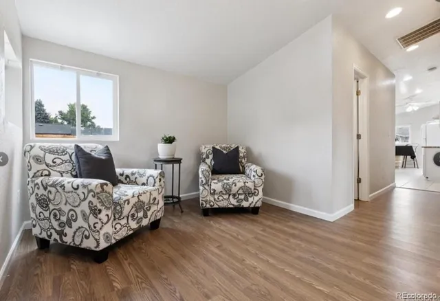 a living room with furniture and a wooden floor