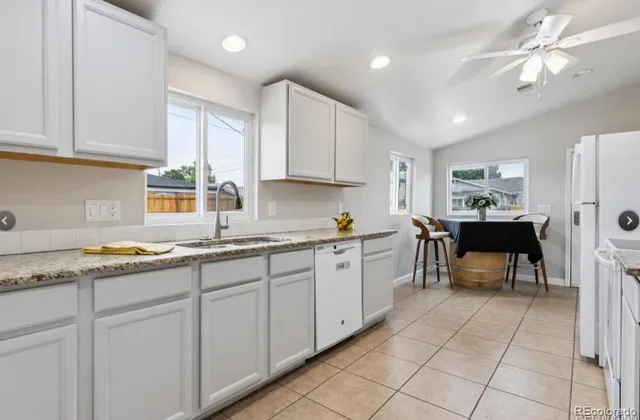 a kitchen with granite countertop a sink cabinets and window