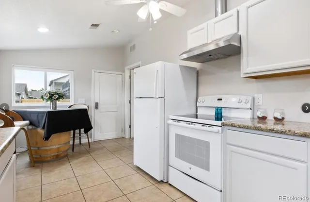 a kitchen with cabinets and chairs