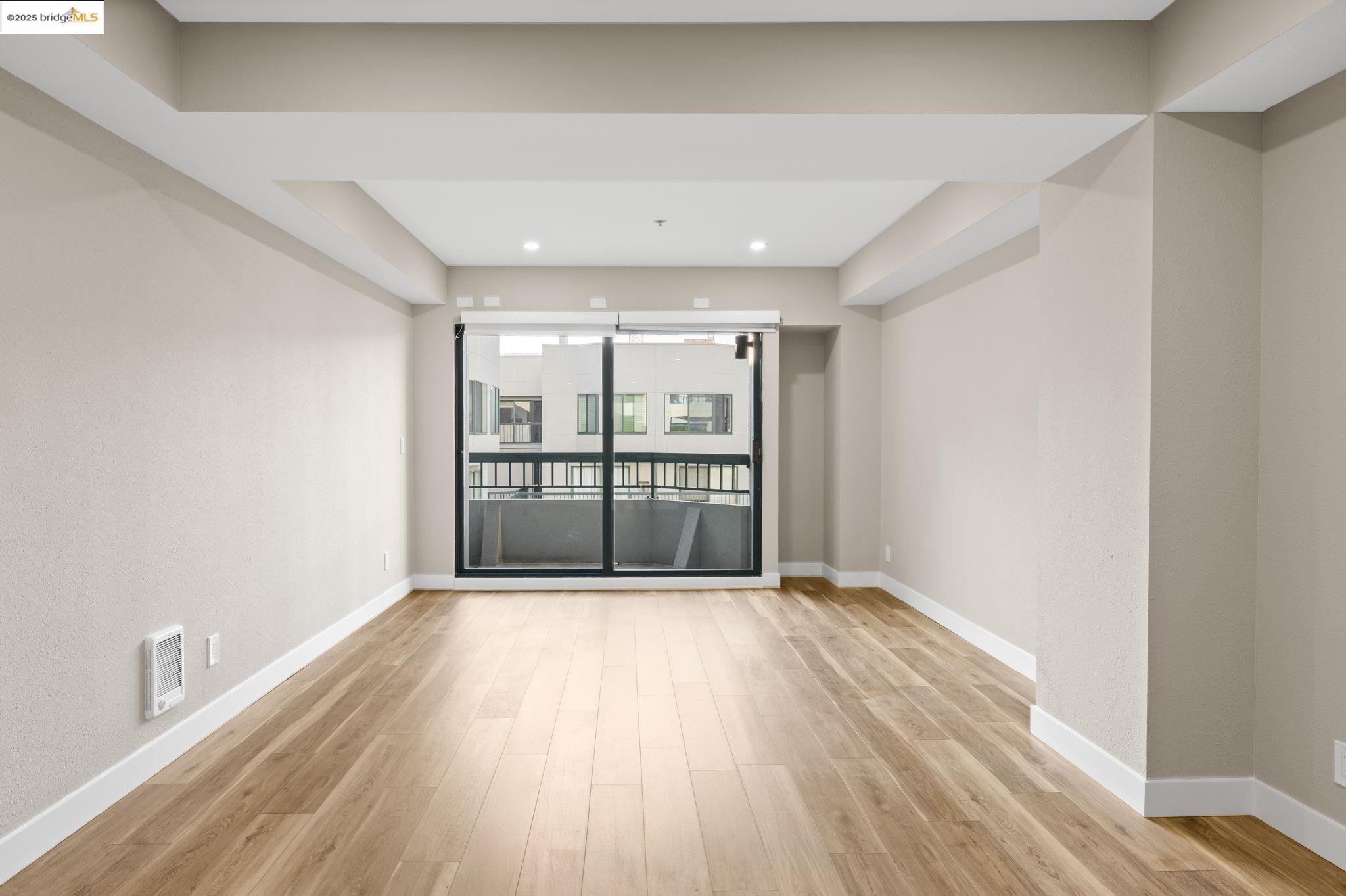 601 Van Ness Avenue, Unit 441 San Francisco, CA 94102 - Photo 11 of 58 a view of an empty room with wooden floor and a window