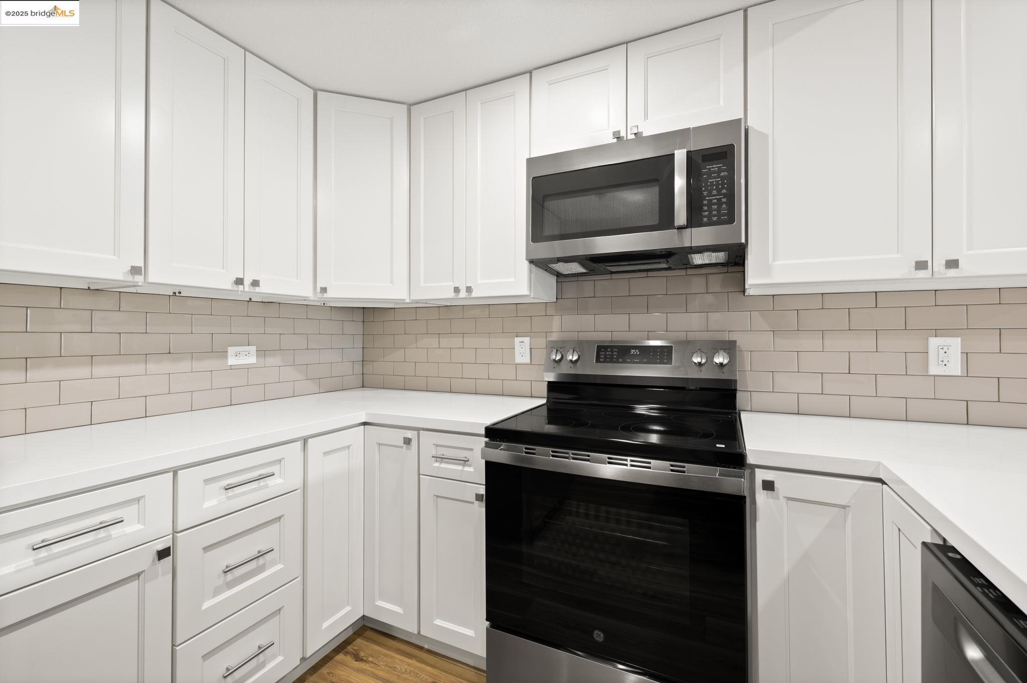 601 Van Ness Avenue, Unit 441 San Francisco, CA 94102 - Photo 17 of 58 a kitchen with white cabinets and black appliances