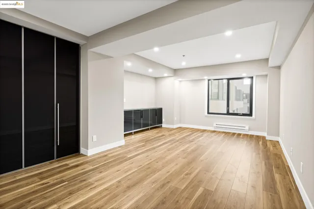 an empty room with wooden floor and cabinet