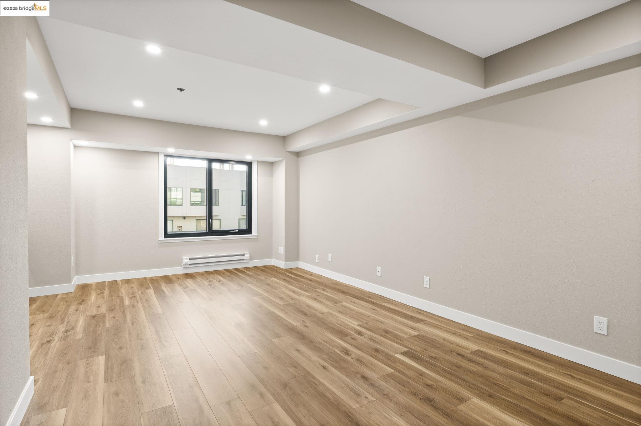 601 Van Ness Avenue, Unit 441 San Francisco, CA 94102 - Photo 24 of 58 a view of an empty room with wooden floor and a window