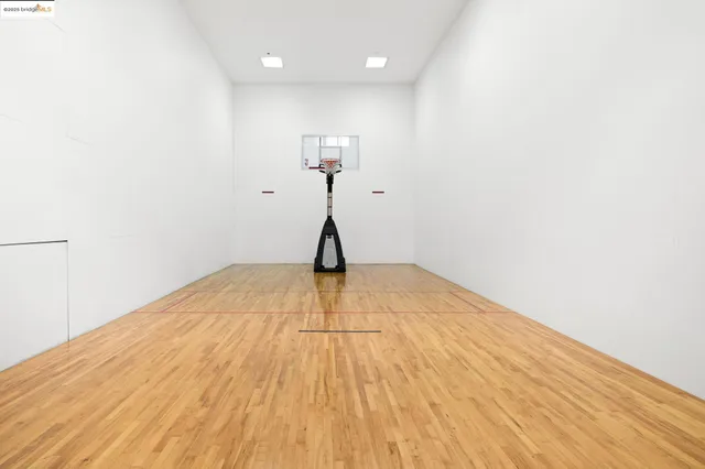 a view of a room with wooden floor and a ceiling fan