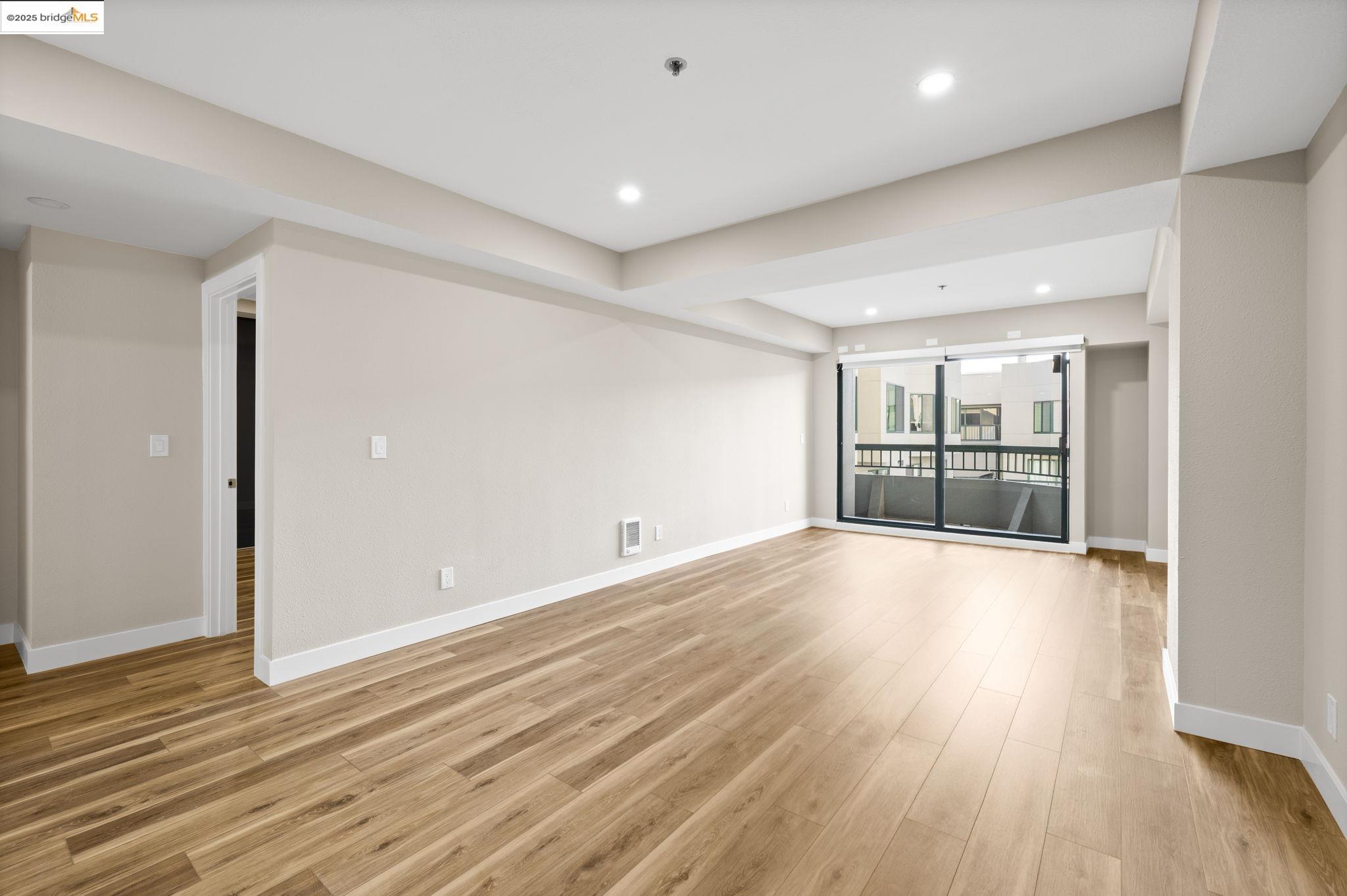 601 Van Ness Avenue, Unit 441 San Francisco, CA 94102 - Photo 5 of 58 an empty room with wooden floor and windows