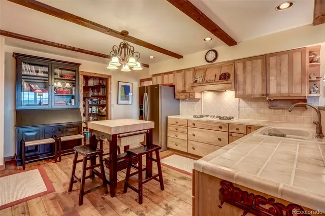 a kitchen that has a lot of counter space and wooden floor