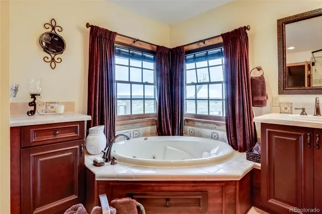 a spacious bathroom with a tub sink and mirror