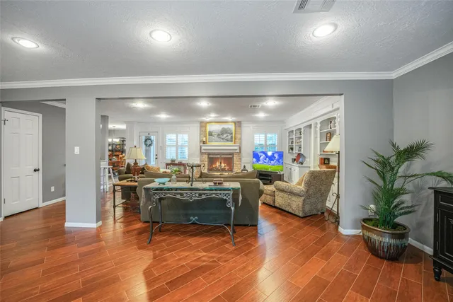 a living room with furniture a potted plant and kitchen view