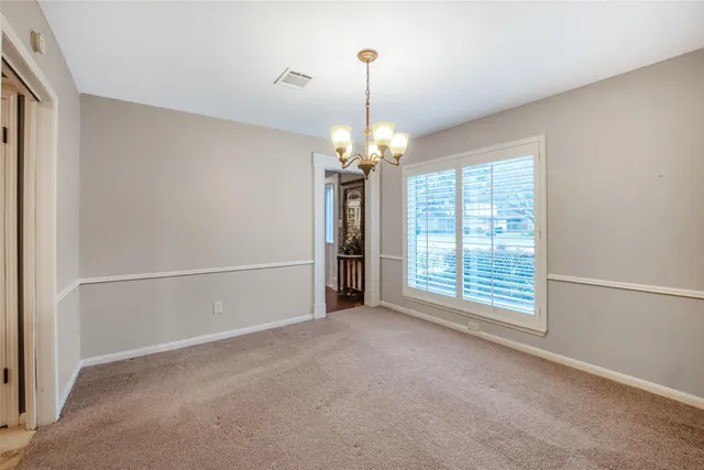 a view of a livingroom with a chandelier fan and a window
