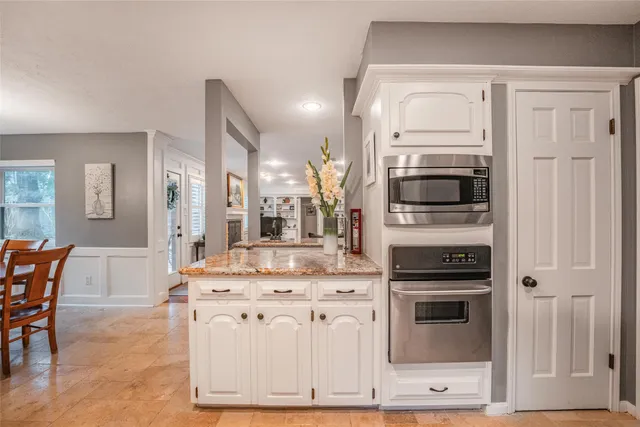 a kitchen with stainless steel appliances kitchen island granite countertop a stove a sink and a microwave