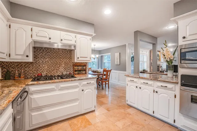 a kitchen with white cabinets and appliances