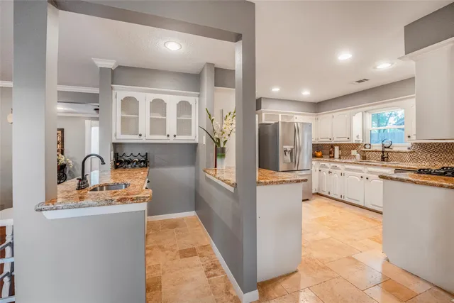 a kitchen with stainless steel appliances granite countertop a refrigerator and a stove top oven